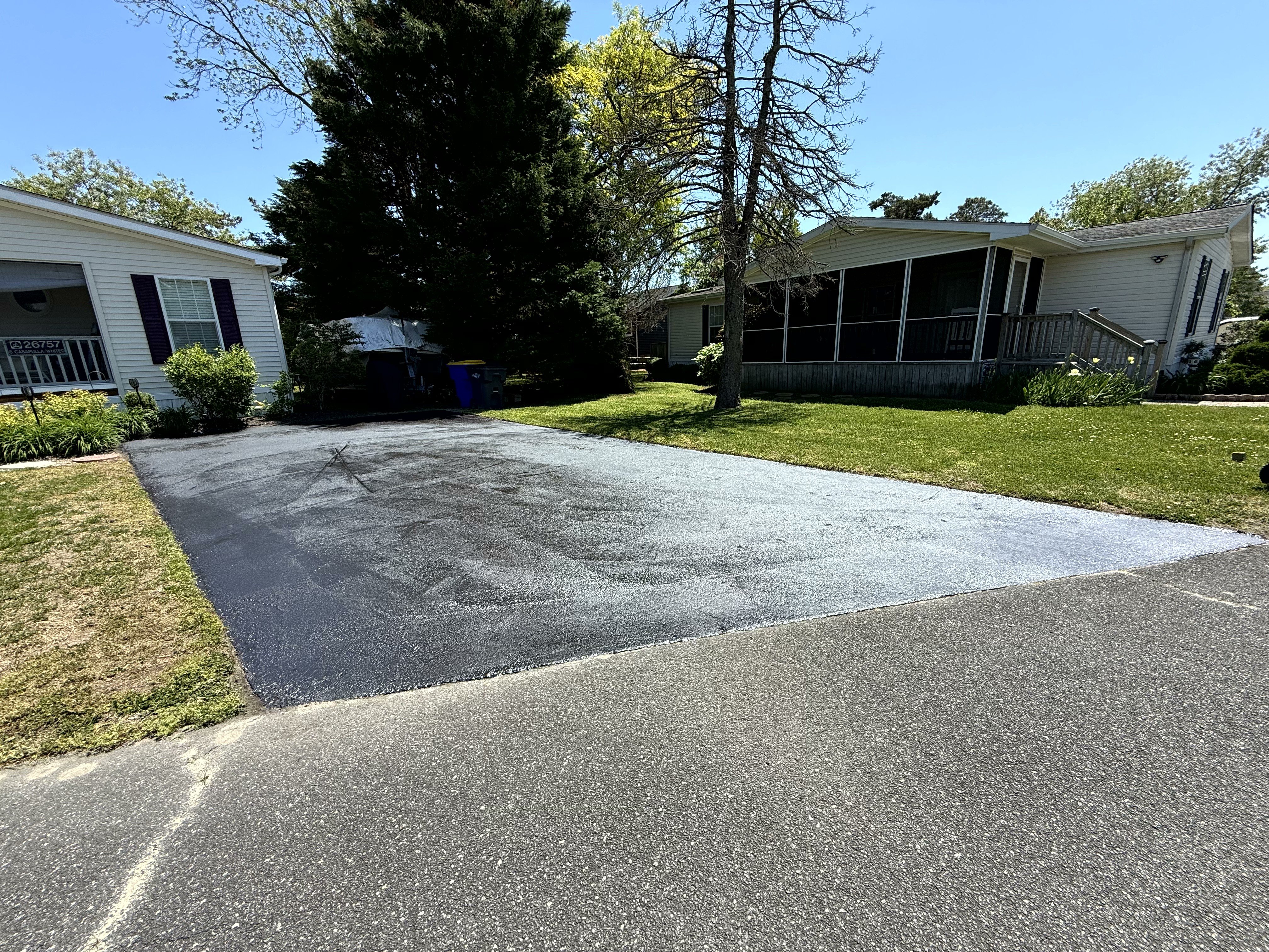 Same driveway after sealcoating, deep black finish