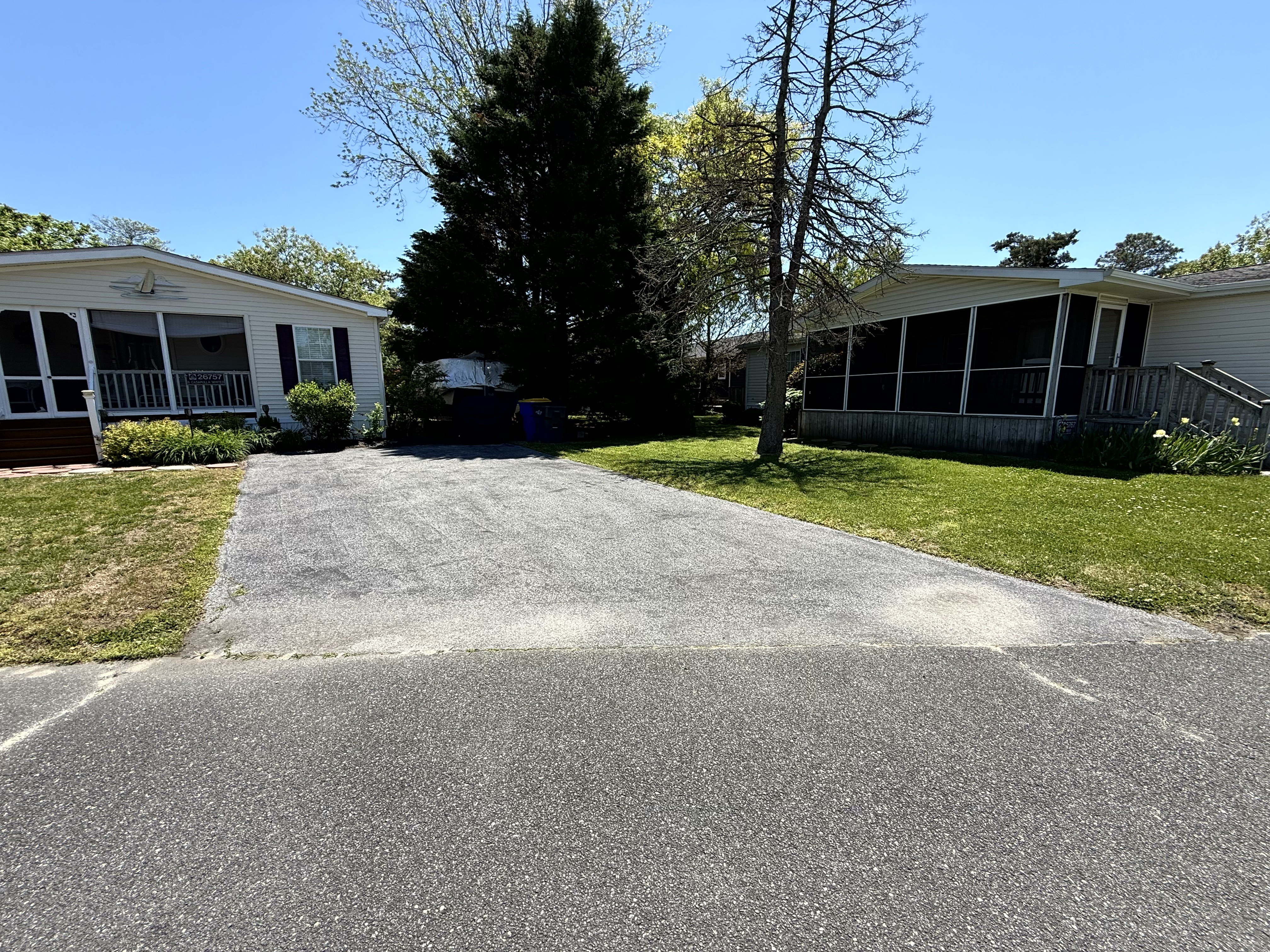 Faded oxidized driveway before sealcoating, visible tire wear
