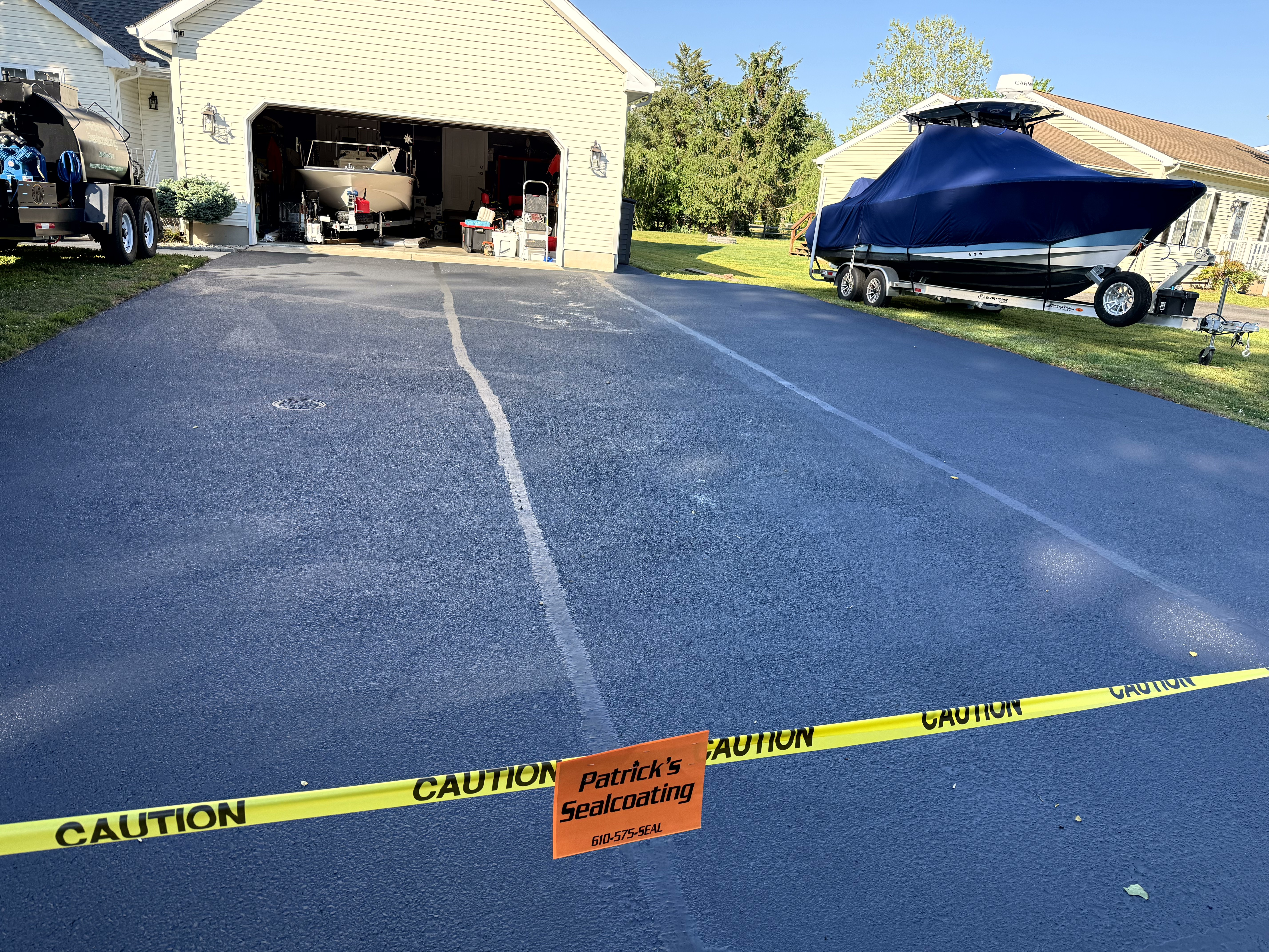 Same driveway from second angle, Patrick's Sealcoating caution tape across the entrance